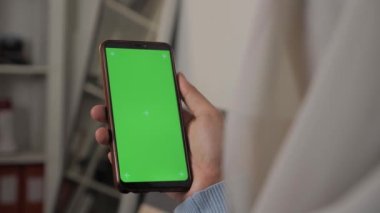 Akıllı telefon modelini kapat, elinde yeşil ekran şablonu olan telefonu tutan kadın