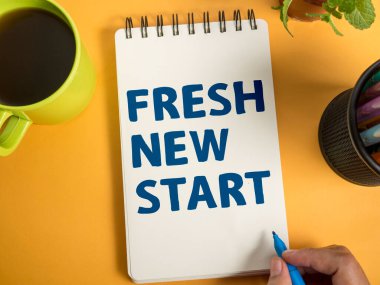 Taze Yeni Başlangıç, sarı arkaplan, yaşam ve iş motivasyon konseptine karşı kitap üzerine yazılmış metin yazıları