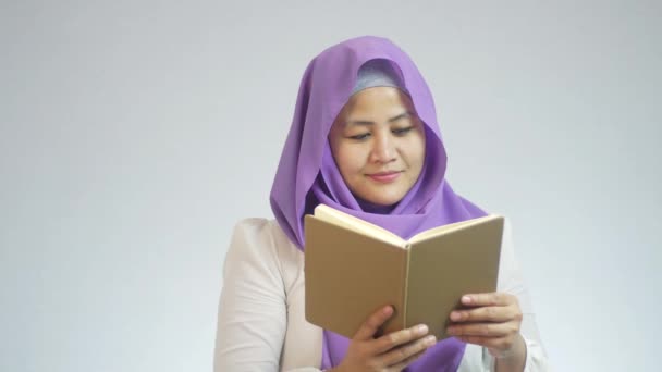 Красивая Азиатская Мусульманка Смеется Читает Книгу Читает Смешную Историю — стоковое видео