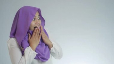 Beyaz arka planda tesettürlü, tesettürlü, tesettürlü, güzel Müslüman bir kadının portresi.