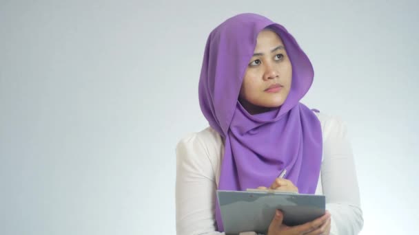 Piękny Azjatycki Muzułmanin Kobieta Robi Kontrolę Jakości Patrząc Bok Pisanie — Wideo stockowe