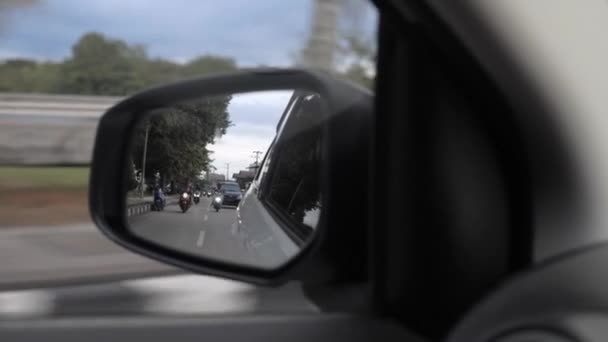 Car driving on the road. Reflection in a car mirror, car speeding on the street. — Stock Video