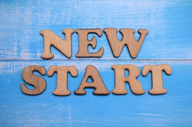Yeni Başlangıç, ahşap arkaplan, yaşam ve iş motivasyon konsepti üzerine yazılmış metin sözcükleri tipografisi
