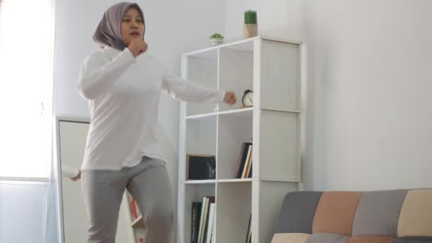 ラップトップでオンラインビデオの指示を見ている間に自宅で運動をするヒジャーブを身に着けているアジアのイスラム教徒の女性 屋内ホームワークアウトの概念 新しい通常のライフスタイルに健康を維持 膝が発生します — ストック動画