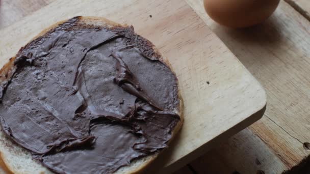 Bröd skiva med choklad grädde, smaskig frukost, höga kolhydrater socker och kalorier mat — Stockvideo