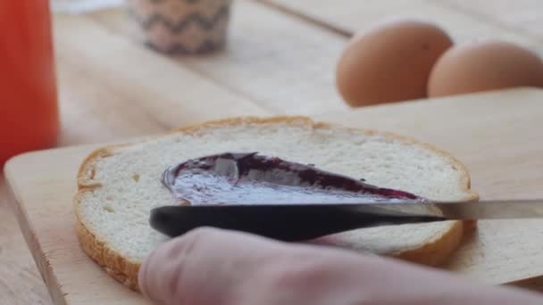 Close-up van de man die bosbessenjam op sneetje brood, ontbijt voedsel maaltijd — Stockvideo