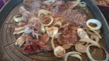 Et ve deniz ürünleri ızgarasını ocakta yakın, Kore yemeklerinde Asya japoncası pişirin.