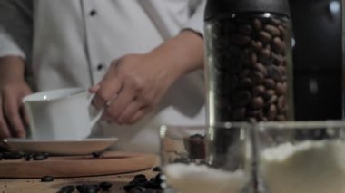 Hazır kahve yapmak, barmen kahve bardağına kahve tozu dökmek.