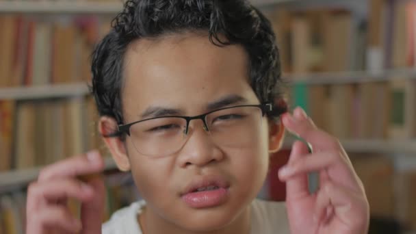 Портрет азиатского мальчика, регулирующего очки, студента с проблемным зрением — стоковое видео