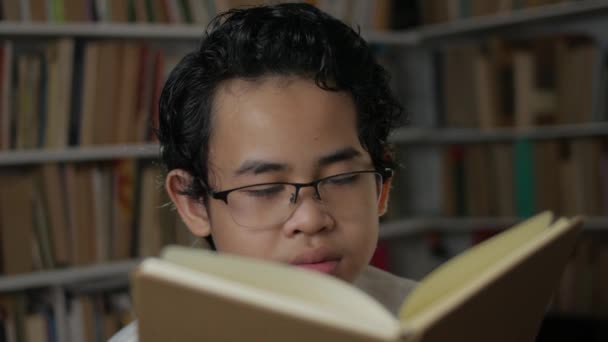 Portrét mladého asijského studenta unavený ospalý a zívání při čtení knihy, student unavený při studiu tvrdé koncepce — Stock video