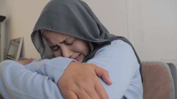 悲しいアジアのイスラム教徒の女性ヒジャーブ泣きを着て、頭痛の痛みやストレスうつ病に苦しんで — ストック動画
