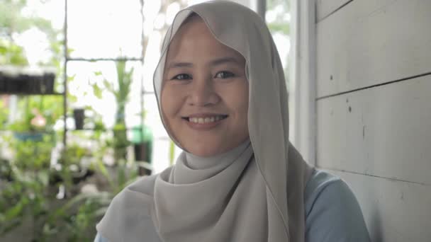 Retrato de una hermosa mujer musulmana asiática con hijab sonriendo a la cámara — Vídeos de Stock