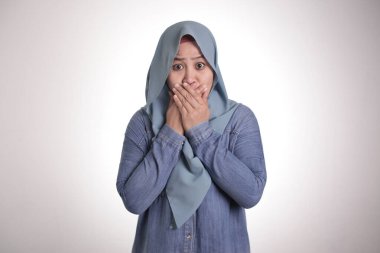 Asyalı Müslüman kadının tesettürlü portresi, parmaklarıyla ağzını kapatıyor. Endişeli bir jest, bir şey diyemem. Önemli bir şey için nefesimi tutuyorum.