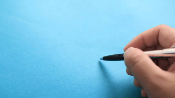 Nahaufnahme Einer Person Mit Stift Schreibposition Über Blauem Hintergrund Kopiervorlage — Stockfoto