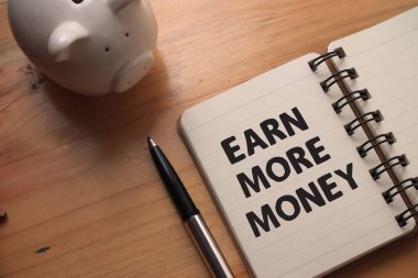 Daha fazla para kazan, ahşap arka plan, hayat ve iş motivasyon konseptine karşı kitap üzerine yazı yaz