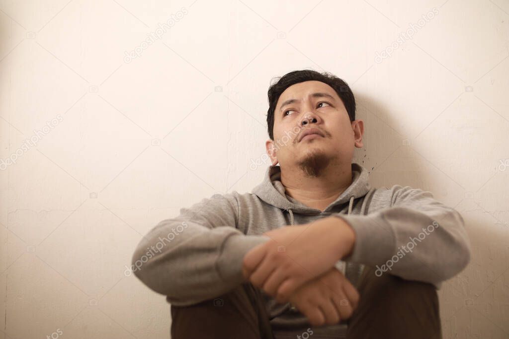 Sad depressed anxiety Asian man thinking contemplating bad thing happened in his life, stress exhausted feeling down expression, financial or relationship problem concept