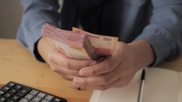 Menutup jumlah perempuan tangan menghitung uang rupiah Indonesia dan membuat catatan, konsep pengelolaan keuangan uang — Stok Video