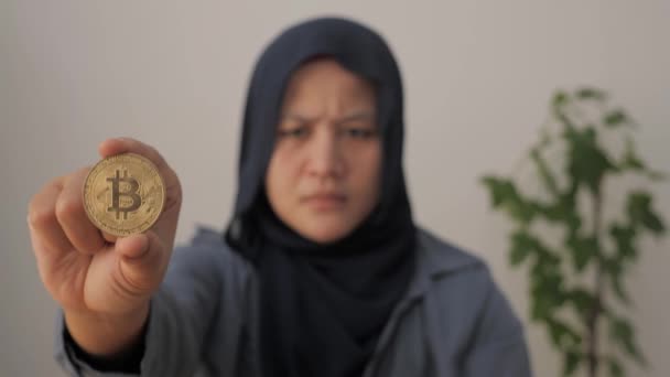 持有比特币加密货币，思维混乱的亚洲穆斯林妇女。数字资产投资概念 — 图库视频影像