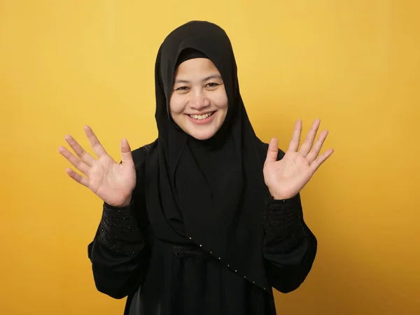 イスラム教徒の女性の肖像画身に着けているヒジャーブカメラを見て笑顔と手を振って言っHiまたは別れのジェスチャーに対する黄色の背景 — ストック写真