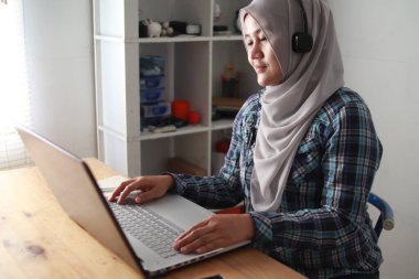 Asyalı Müslüman kadının evinde bilgisayarında video telekonferansı, online öğrenme ya da ev konseptinden çalışma