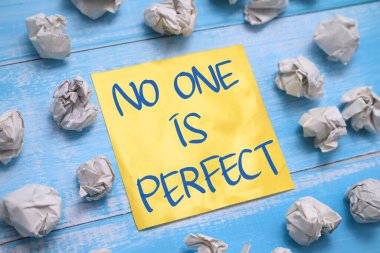 Kimse mükemmel değildir. Tahta arka plan, yaşam ve iş motivasyon konseptine karşı kağıda yazılmış yazı karakterleri.