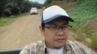 Kamyonetin arkasında oturan Asyalı adam, vahşi konseptte safari gezisi macerası.