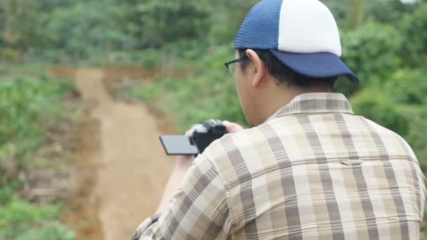 Азиатский Фотограф Видеограф Держащий Руках Камеру Снимающий Естественную Дикую Природу — стоковое видео