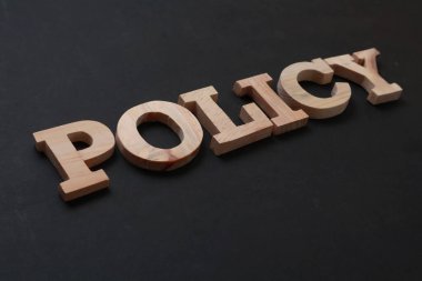 Politika, metin sözcükleri tipografisi, siyah arkaplan, yaşam ve iş motivasyon kavramı üzerine ahşap harflerle yazılmış.