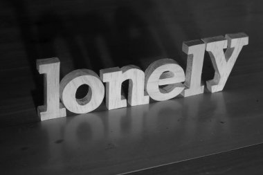 Yalnız, yazı karakteri kara arkaplan, hayat ve iş olumsuzluğu kavramı üzerine ahşap harflerle yazılmış.