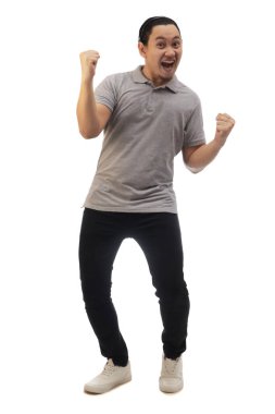 Asyalı adam gri gömlekli siyah kot ve beyaz ayakkabılı, çığlık çığlığa zaferi kutluyor, jest kazanıyor. Tüm vücut portresi izole edildi.