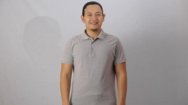 Boş yakalı gömlek şablon, ön görüş, beyaz üzerinde sade gri tişört giyen Asyalı erkek model. Baskı için polo tee tasarımı modelleme sunumu
