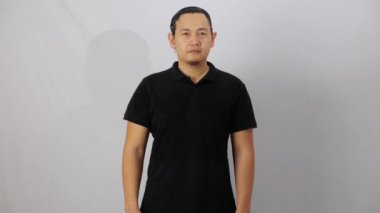 Boş yakalı gömlek şablon, ön görüş, beyaz üzerine izole edilmiş sade siyah tişört giyen Asyalı erkek model. Baskı için polo tee tasarımı modelleme sunumu