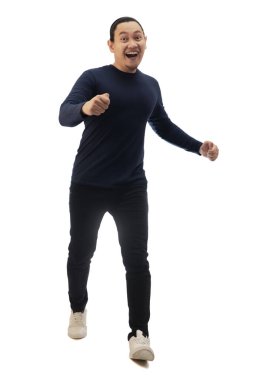Sıradan mavi gömlekli, siyah kot ve beyaz ayakkabılı bir adam öne doğru koşuyor, özgüvenle hareket ediyor, önden bakıyor. Tüm vücut portresi izole edildi.