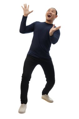 Sıradan mavi gömlekli, siyah kot ve beyaz ayakkabılı bir adam, yukarıdan inanılmaz bir şey beklerken şaşkın ve mutlu. Tüm vücut portresi izole edildi.