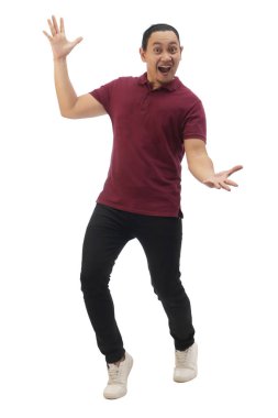 Günlük kırmızı gömlek giyen siyah kot ve beyaz ayakkabı giyen, gülümseyen ve kameraya bir şey gösteren bir adam. Tüm vücut portresi izole edildi.