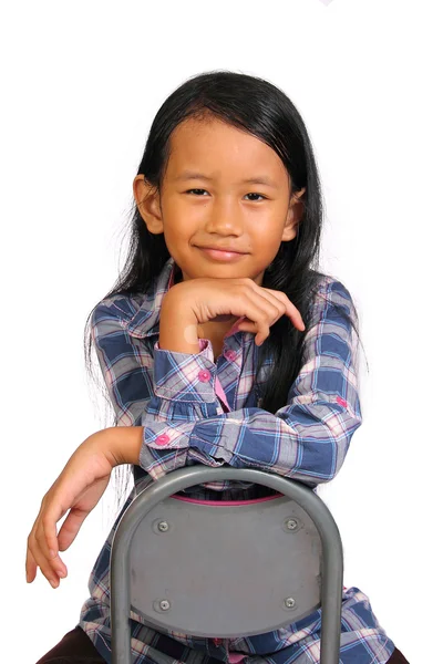 Маленькая девочка улыбается с рукой под подбородком — стоковое фото