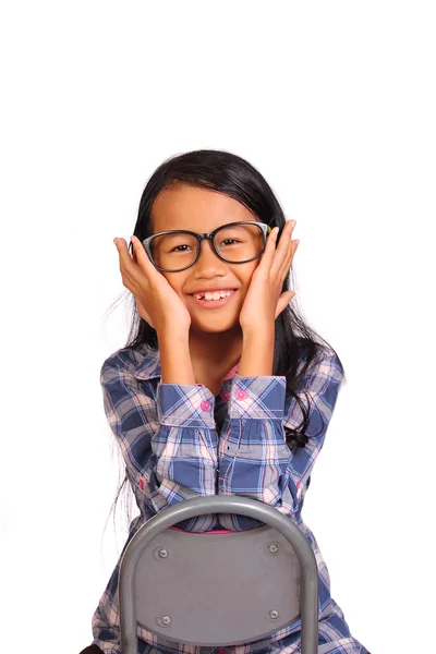 Kleines Mädchen lächelt und berührt ihre Wange — Stockfoto