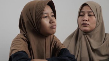 Asyalı Müslüman anne kızıyla yakın konuşuyor, derin sohbetler ediyor ve hikayelerini paylaşıyor.