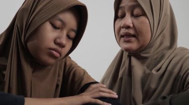Asyalı Müslüman anne, kızgın, hayal kırıklığına uğramış ve inatçı kızını ikna etmeye ve sakinleştirmeye çalışıyor.