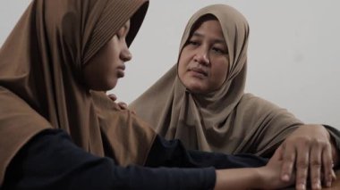 Asyalı Müslüman anne, kızgın, hayal kırıklığına uğramış ve inatçı kızını ikna etmeye ve sakinleştirmeye çalışıyor.