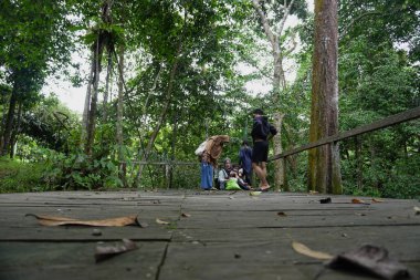Asyalı Müslüman anne, ormanın ortasında oğlu ve kızıyla piknik yapıyor. Aile bağları kuruyor.