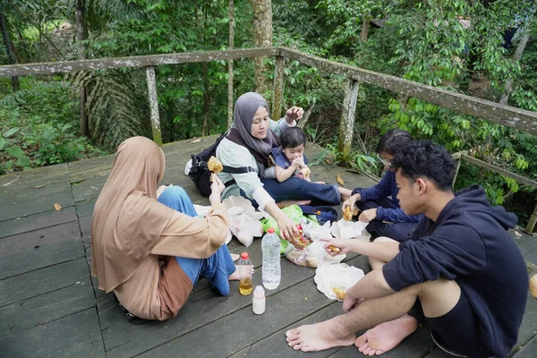 Asyalı Müslüman anne, ormanın ortasında oğlu ve kızıyla piknik yapıyor. Aile bağları kuruyor.
