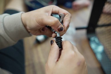 Evdeki küçük bir depoya tekerlek monte eden ve montajlayan isimsiz bir kadının ellerini kapatın, DIY mobilya montaj ve ev geliştirme konsepti