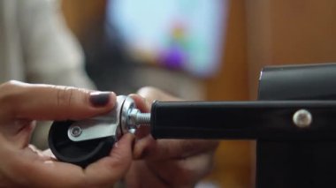 Evdeki küçük bir depoya tekerlek monte eden ve montajlayan isimsiz bir kadının ellerini kapatın, DIY mobilya montaj ve ev geliştirme konsepti