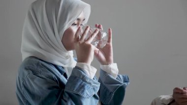 Bir kafede arkadaşıyla yemek yerken gülümseyen ve gülen güzel Asyalı Müslüman bir genç kızın portresini yakından çek.