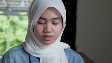 Bir kafede arkadaşıyla yemek yerken gülümseyen ve gülen güzel Asyalı Müslüman bir genç kızın portresini yakından çek.