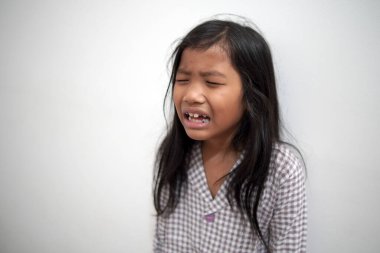 Üzgün küçük Asyalı kız gözyaşlarıyla ağlıyor, üzgün çocuk hayal kırıklığına uğruyor ve üzülüyor, çocukluk zorbalığı kavramı, yalnızlık ve duygusal travma.