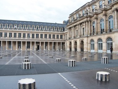 Palais Royal Cour d 'Honneur Les Colonnes de Buren - Tarihi Palais Royal avlusu ve Daniel Buren' in çizgili sütunları (Les Deux Plateaux) Paris 'te gri, bulutlu bir günde.