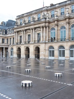 Palais Royal Cour d 'Honneur Les Colonnes de Buren - Tarihi Palais Royal avlusu ve Daniel Buren' in çizgili sütunları (Les Deux Plateaux) Paris 'te gri, bulutlu bir günde.