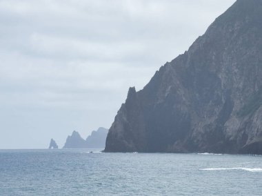 Madeira Deniz Yığını Üzerinde Altın Gün Batımı - Madeira 'daki Ilhus da Ribeira da Janela volkanik deniz yığınlarının gün batımında atmosferik manzarası, kayalık plaj ve Atlantik Okyanusu' nun üzerine düşen altın bir ışık.